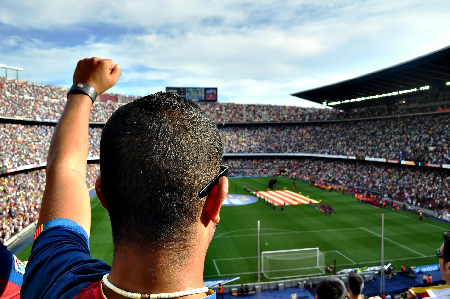 person in red and blue top raising left hand